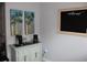 Coffee station setup on a light mint green colored cabinet featuring palm tree art and a welcome sign above at 414 Grand Cypress Way, Murrells Inlet, SC 29576