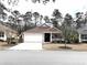 Traditional-style home with an attached two-car garage, neutral siding, and a welcoming front porch at 414 Grand Cypress Way, Murrells Inlet, SC 29576