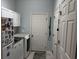 Well-organized laundry room with white cabinets, a modern washer and dryer, and extra storage space at 414 Grand Cypress Way, Murrells Inlet, SC 29576