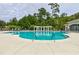 Community pool with crystal-clear water, surrounded by lounge chairs, lush trees, and a pergola at 414 Grand Cypress Way, Murrells Inlet, SC 29576