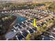 An aerial view displays a well-planned neighborhood with lush landscaping and a serene pond at 440 Craigflower Ct., Longs, SC 29568