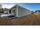 Back view of the home with gray siding and a concrete patio and screened in porch with neatly landscaped yard at 440 Craigflower Ct., Longs, SC 29568
