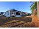 View of the back of the home with a lawn and a screened-in porch with concrete patio in a quiet neighborhood at 440 Craigflower Ct., Longs, SC 29568