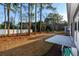 Lawn view of backyard with trees, a white fence, and a concrete patio at 440 Craigflower Ct., Longs, SC 29568