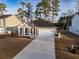 Charming one-story home featuring a two-car garage, long driveway, covered porch, and well-manicured front lawn at 440 Craigflower Ct., Longs, SC 29568