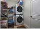 Laundry area featuring stacked washer and dryer with shelving, a sink, and storage solutions at 440 Craigflower Ct., Longs, SC 29568