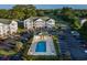Aerial view of condo buildings, a pool, and a golf course surrounded by trees on a sunny day at 4459 Turtle Ln. # 3D, Little River, SC 29566