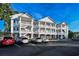 Exterior of condo building featuring white siding, balconies, and parking lot at 4459 Turtle Ln. # 3D, Little River, SC 29566