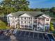 Straight on exterior shot of three story condominium building with brick base and white siding at 4459 Turtle Ln. # 3D, Little River, SC 29566