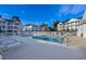 Community pool with lounge chairs and tables surrounded by a white fence, near condo buildings at 4459 Turtle Ln. # 3D, Little River, SC 29566