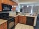 Modern kitchen with granite countertops, black appliances, and wood cabinets at 5300 N Ocean Blvd. # 1005, Myrtle Beach, SC 29577