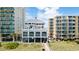 Exterior view of a coastal building with balconies surrounded by palm trees and other buildings at 5825 Catalina Dr. # 332, North Myrtle Beach, SC 29582