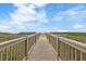 Wooden walkway with railing leading to a grassy area and a view of the ocean at 5825 Catalina Dr. # 332, North Myrtle Beach, SC 29582