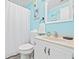 Bathroom with tiled countertops, white cabinetry, and beach themed decor at 5905 S Kings Hwy. # 312-C, Myrtle Beach, SC 29575