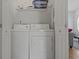 Bright laundry room with washer, dryer, and shelving at 6001-1830A S Kings Highway, Myrtle Beach, SC 29575