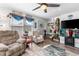 Comfortable living room featuring ceiling fan, decor, stairs to the second floor, and a large window at 6702 Jefferson Pl. # B6, Myrtle Beach, SC 29572