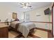 Bedroom with light wood flooring, ceiling fan, and decor, including a mounted TV and decorative accents at 720 Dove Haven Ln., Myrtle Beach, SC 29579