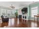 Cozy living room with hardwood floors, a fireplace, a ceiling fan, and large windows at 720 Dove Haven Ln., Myrtle Beach, SC 29579