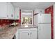 Galley kitchen with white cabinets and view into living area at 7601 N Ocean Blvd. # 5A, Myrtle Beach, SC 29572