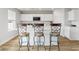 Kitchen island with counter stools, modern white cabinets, and stainless steel appliances at 1052 Kinness Dr., Conway, SC 29527