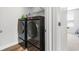 Contemporary laundry room with black front-loading washer and dryer on risers with storage at 1052 Kinness Dr., Conway, SC 29527