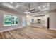 Bright living room featuring hardwood floors, coffered ceiling, and an open-concept design to the kitchen at 106 Riverwatch Dr., Conway, SC 29527