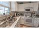 Well-lit kitchen featuring white appliances, cabinets, neutral countertop, and stainless steel sink at 1061 Pinwheel Loop # 1061, Myrtle Beach, SC 29577