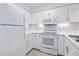 White kitchen features ample cabinetry and a microwave at 108 Rothbury Circle # 207, Myrtle Beach, SC 29572