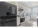 Well-equipped kitchen featuring white cabinets, stainless steel appliances, and a modern black refrigerator at 116 Cypress Estates Dr., Murrells Inlet, SC 29576