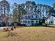 Charming blue two-story home with a welcoming front porch and mature trees at 116 Great Lakes Rd., Pawleys Island, SC 29585