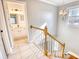 Upstairs hallway with view of the bathroom and stairway, and a chandelier overhead at 116 Great Lakes Rd., Pawleys Island, SC 29585