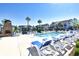 Community pool with lounge chairs, outdoor fireplace, and palm trees under a clear blue sky at 118 Birch N Coppice Dr. # 3, Surfside Beach, SC 29575