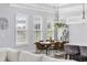 Dining area with large windows, modern light fixture and wooden table at 1196 Fiddlehead Way, Myrtle Beach, SC 29579