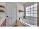 Relaxing bathroom featuring a sleek, modern tub with jets next to a window and with neutral wall paint at 124 Blue Jacket Dr., Galivants Ferry, SC 29544