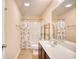 Bright bathroom featuring a vanity with sink, toilet, and shower with neutral tones and decorative floral shower curtain at 128 Belclare Way, Longs, SC 29568