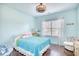 The charming bedroom is decorated in coastal colors with a ceiling fan and a sunny window at 128 Belclare Way, Longs, SC 29568