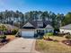 Charming single Gathering home with a well manicured front yard and an attached two car garage at 128 Belclare Way, Longs, SC 29568