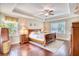 Main bedroom with a tray ceiling, hardwood floors, and abundant natural light from multiple windows at 128 Belclare Way, Longs, SC 29568