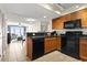 Galley kitchen featuring black appliances and tile flooring adjacent to a cozy living area with a view at 1321 S Ocean Blvd. # 1101, North Myrtle Beach, SC 29582