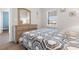Bright bedroom featuring a patterned quilt, wood flooring, and light wood dresser with mirror at 136 Birch N Coppice Dr. # 11, Surfside Beach, SC 29575