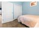 A simple bedroom with wood floors, blue walls, closet doors, and a bed with coral comforter at 136 Birch N Coppice Dr. # 11, Surfside Beach, SC 29575