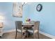 Cozy dining area features a round table, four chairs and a colorful floral centerpiece at 136 Birch N Coppice Dr. # 11, Surfside Beach, SC 29575