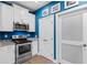 Kitchen featuring stainless steel appliances, granite counters and white cabinets with bright blue wall at 136 Birch N Coppice Dr. # 11, Surfside Beach, SC 29575
