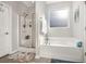 Bathroom featuring a white bathtub and glass-enclosed shower at 1377 Tessera Way, Myrtle Beach, SC 29579