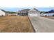 Gray house with white garage door, landscaping, and a long driveway at 142 Bancroft Dr., Conway, SC 29527