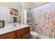 Well-lit bathroom featuring a floral shower curtain, stylish vanity, and storage cabinet at 1425 Tiger Grand Dr., Conway, SC 29526