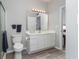 A clean bathroom featuring a shower, toilet, vanity, and a large mirror that is well-lit at 1525 Lanterns Rest Rd. # 102, Myrtle Beach, SC 29579