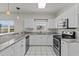 White cabinets, granite counters, stainless appliances, and tile floors outfit this bright and airy kitchen at 1538 Lanterns Rest Rd. # 103, Myrtle Beach, SC 29579