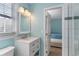 Bathroom boasts a white vanity, large mirror, and tiled shower at 719 N Waccamaw Dr., Murrells Inlet, SC 29576