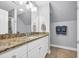 Bright bathroom with a granite countertop, white cabinets, and a large mirror at 212 Minnow Ln., Murrells Inlet, SC 29576